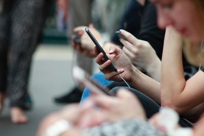 Several people looking down at mobile phones.
