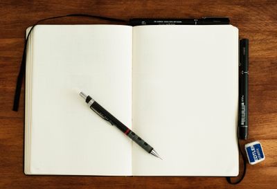 Black and silver retractable pen on blank notebook.