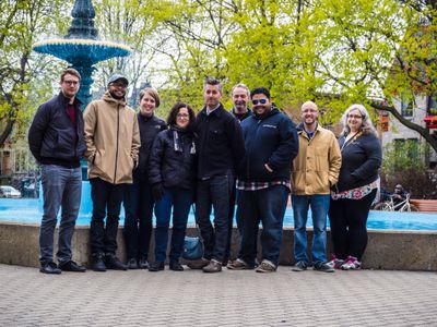 Eight members of the Theme Team, plus Ian Stewart, standing in front of a fountain.